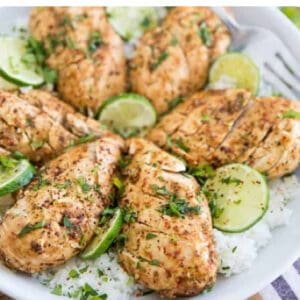 Grilled chicken drumsticks garnished with lime slices on a bed of rice.