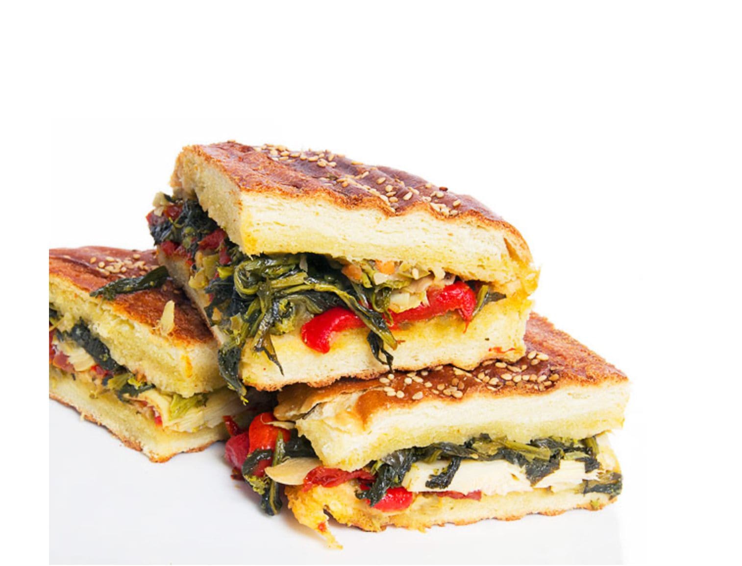 Stack of grilled vegetable sandwiches with melted cheese.
