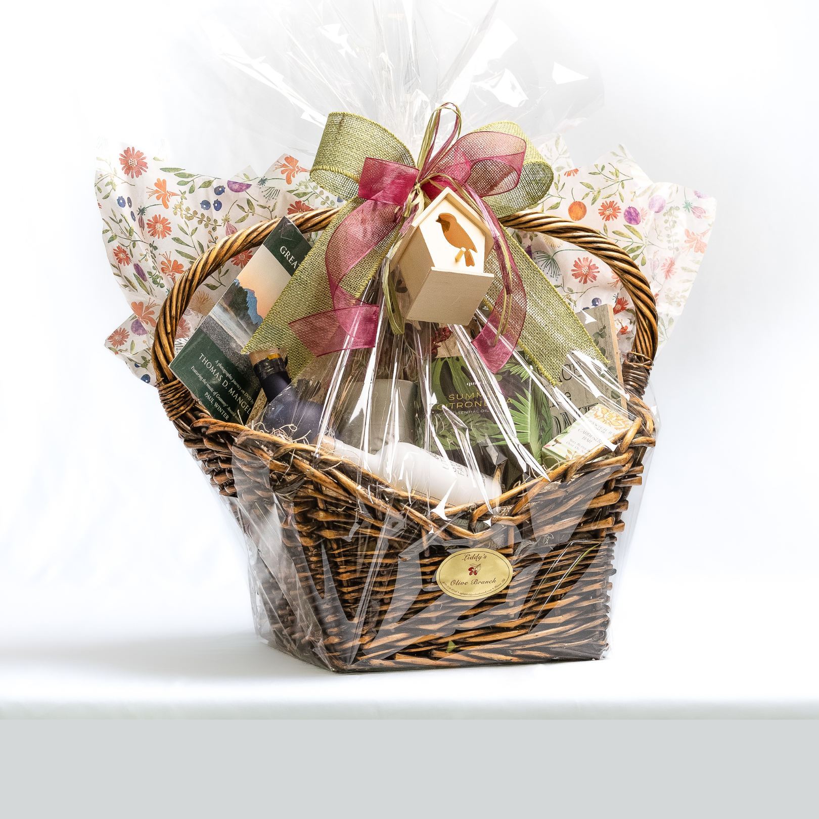 Decorative wicker gift basket wrapped in cellophane with a bow on top.